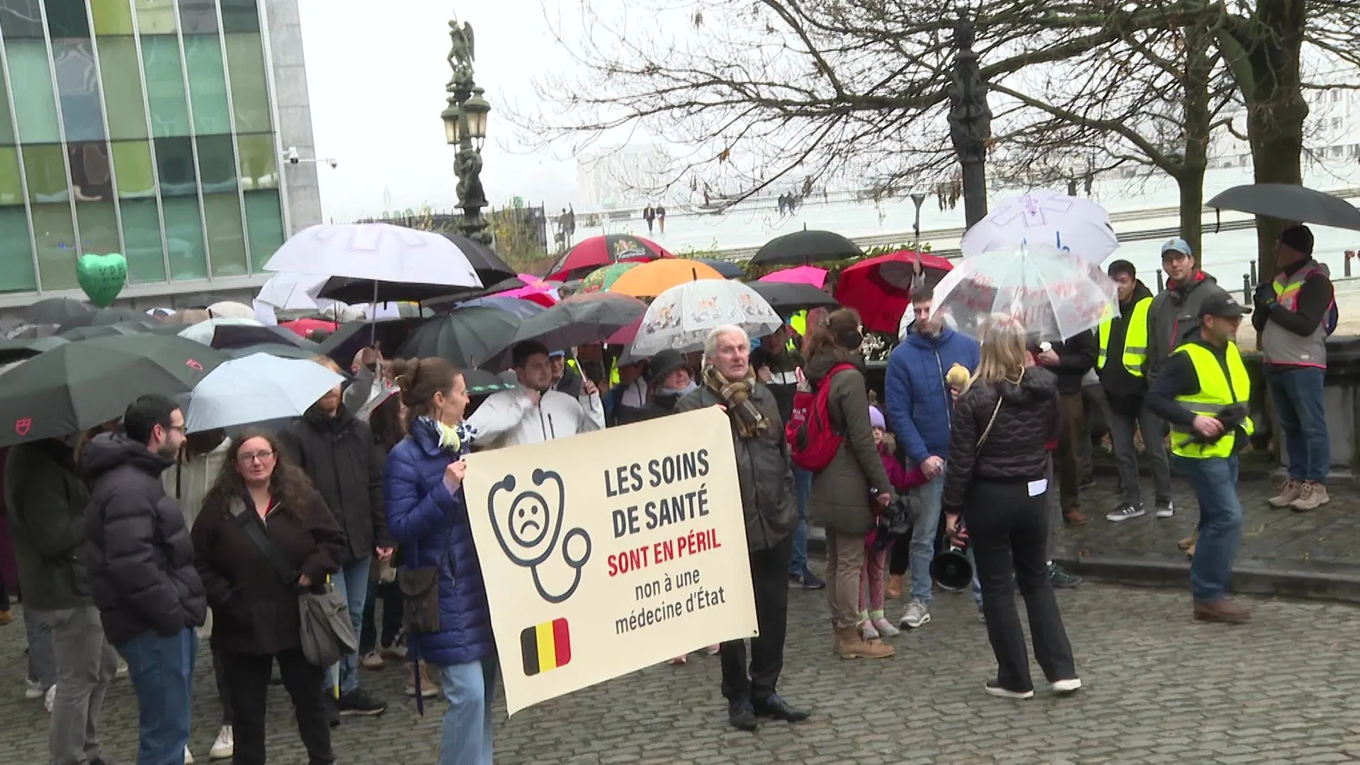 Plusieurs centaines de personnes manifestent sous des parapluies pour ...