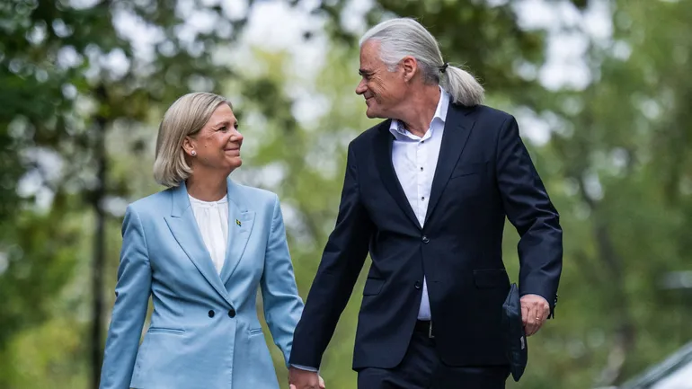 La présidente du Parti social-démocrate, Magdalena Andersson (à gauche), et son mari, Richard Friberg, arrivent pour voter dans un bureau de vote installé dans une école à l'occasion des élections législatives suédoises, à Nacka, le 13 septembre 2026.