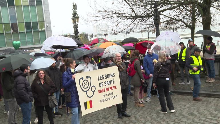Plusieurs centaines de personnes manifestent sous des parapluies pour "protéger la santé" contre la réforme du vice-Premier ministre Vandenbroucke