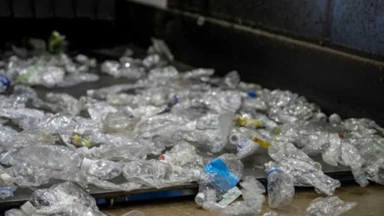 Cette photo prise le 25 octobre 2024 montre des bouteilles en plastique sur un tapis roulant à l’usine de recyclage « Japantech East Japan PET Bottle MR Center » à Kasama, dans la préfecture d’Ibaraki.