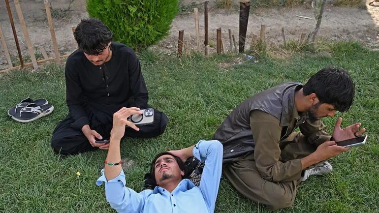 Des étudiants afghans doivent sortir du site universitaire pour utiliser leur smartphone