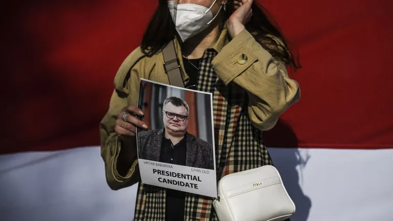 Une femme tient un portrait du politicien biélorusse Viktor Babariko lors d’une manifestation de solidarité avec les prisonniers politiques, le 6 mars 2021 à Lisbonne.
