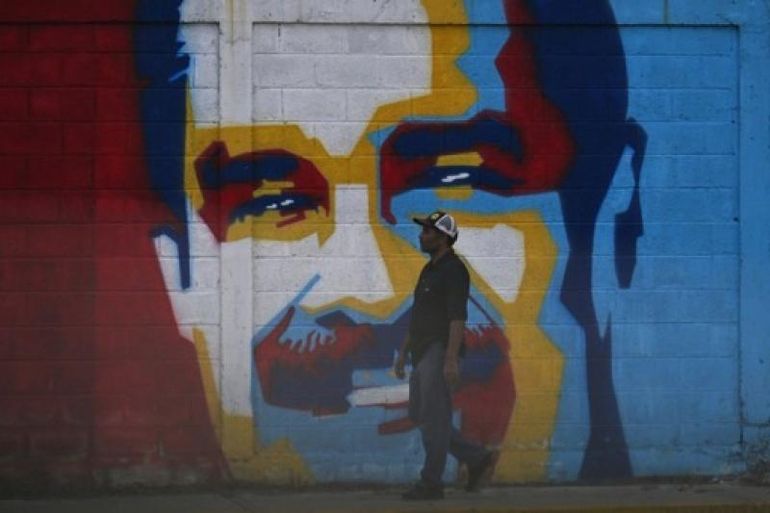 Un homme passe devant un graffiti représentant le président vénézuélien Nicolas Maduro à Caracas, le 3 décembre 2026.