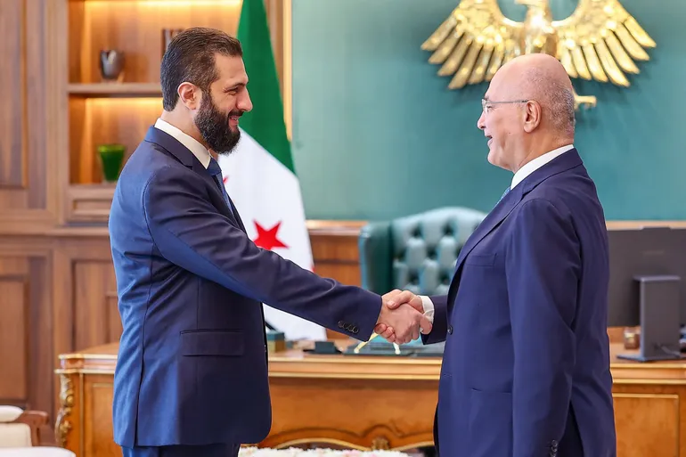 Le président Ahmad al-Sharaa (à gauche) serrant la main du Haut-Commissaire des Nations unies pour les réfugiés (HCR), Barham Salih, et de la délégation qui l’accompagnait, au Palais du Peuple à Damas, le 10 août 2026.